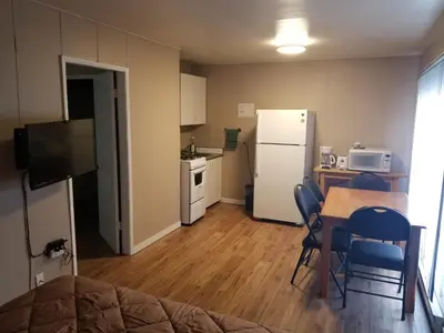 a small kitchen with a table and a refrigerator at Apple Tree Inn in Penticton