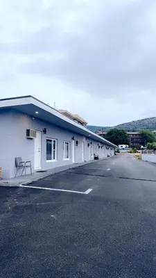 a large white building with a parking lot at Apple Tree Inn in Penticton