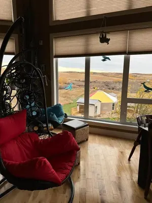 a living room with a chair and a large window at Misty Ridge Retreat B&B in Foothills