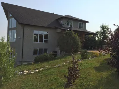a house with a grass yard in front of it at Misty Ridge Retreat B&B in Foothills