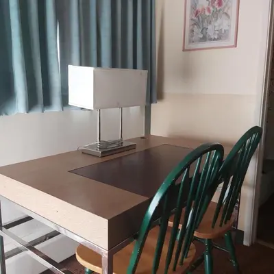 a table with two chairs and a lamp on it at Alpine Lodge Motel & Restaurant in Grande Cache