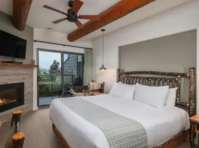 a bedroom with a large bed and a fireplace at Tigh-Na-Mara Seaside Spa Resort in Parksville