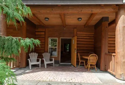 a porch of a wooden house with chairs and a table at Tigh-Na-Mara Seaside Spa Resort in Parksville