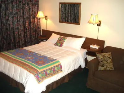 a hotel room with a bed and a chair at Motel Tyrol in Radium Hot Springs