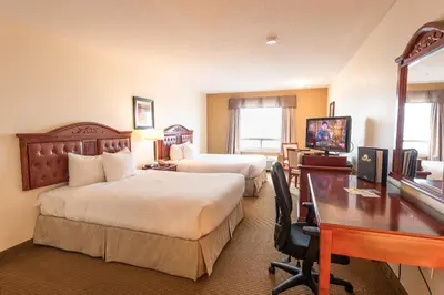 a hotel room with two beds and a desk at Days Inn by Wyndham Bonnyville in Bonnyville