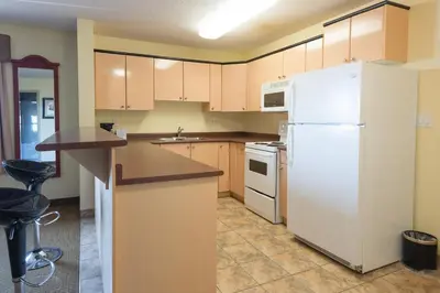 a kitchen with a white refrigerator and a sink at Days Inn by Wyndham Bonnyville in Bonnyville