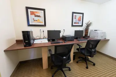 a desk with two computers on top of it at Days Inn by Wyndham Bonnyville in Bonnyville