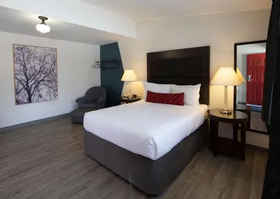 a hotel room with a large bed and a chair at SureStay Hotel by Best Western Castlegar in Castlegar