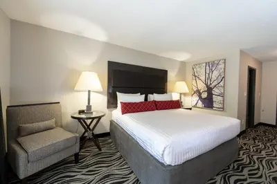 a hotel room with a bed and a chair at SureStay Hotel by Best Western Castlegar in Castlegar
