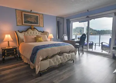 a bedroom with a bed with a view of the water at The Oceanfront Inn on Stephens Bay in Coal Harbour