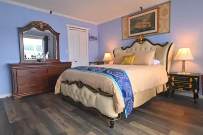 a bedroom with a large bed and a mirror at The Oceanfront Inn on Stephens Bay in Coal Harbour