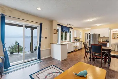 a kitchen and dining room with a view of the ocean at The Oceanfront Inn on Stephens Bay in Coal Harbour