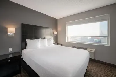 a bedroom with a large white bed and a window at Coast Nisku Inn & Conference Centre in Nisku