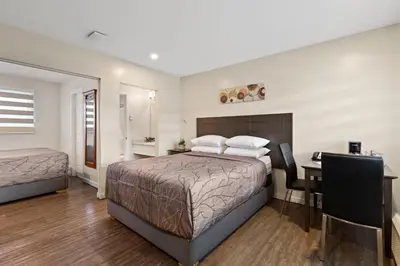 a hotel room with a bed and a desk and a desk at Oasis Inn in Kelowna