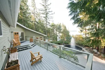 a porch with a bench and a fountain on a house at Rockwater Secret Cove Resort in Sechelt