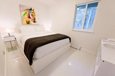 a white bedroom with a bed in a room at Rockwater Secret Cove Resort in Sechelt