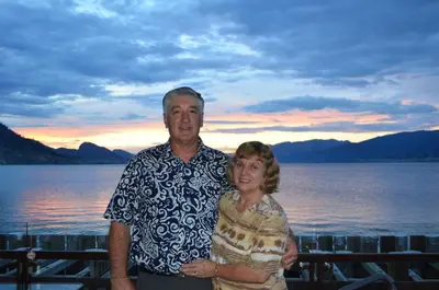 a man and a woman standing in front of the water at Dogwood Bed & Breakfast in Summerland