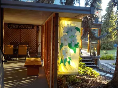 a covered porch with a painting of flowers on the wall at Dogwood Bed & Breakfast in Summerland
