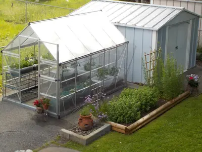 a greenhouse with plants in it in a yard at Dogwood Bed & Breakfast in Summerland