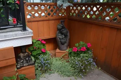 a garden with flowers and a statue next to a fence at Dogwood Bed & Breakfast in Summerland