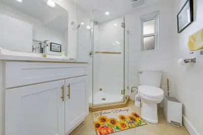 a white bathroom with a shower and a toilet at Quite House near the Vancouver Airport in Richmond