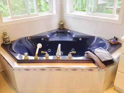 a blue bath tub in a bathroom with a window at Seafarer Bed & Breakfast in Tofino