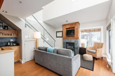 a living room with a couch and a fireplace at Cox Bay Beach Resort in Tofino