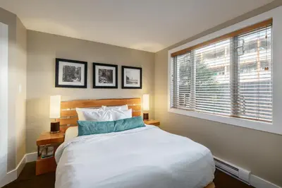 a bedroom with a large white bed and a window at Cox Bay Beach Resort in Tofino