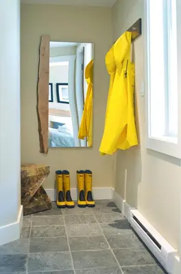 a hallway with yellow rubber boots and a mirror at Cox Bay Beach Resort in Tofino