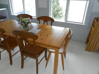 a wooden table with chairs and a vase of flowers on it at Tofino Paddlers Inn in Tofino