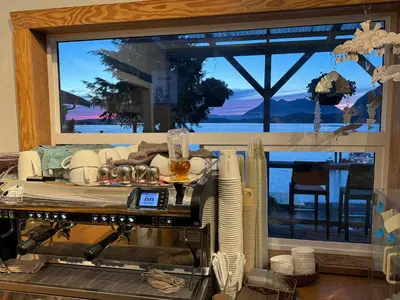 a kitchen with a table with plates and a window at Tofino Paddlers Inn in Tofino