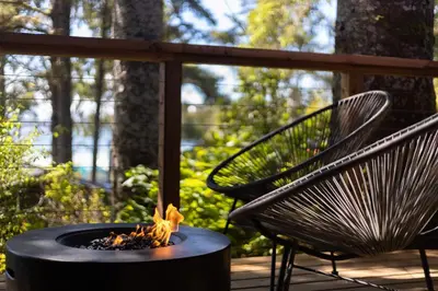 a fire pit and a bench on a deck at Mackenzie Beach Resort in Tofino