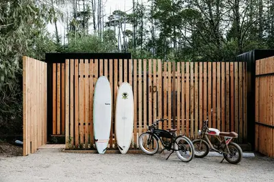 two surfboards leaning against a wooden fence with bicycles at Mackenzie Beach Resort in Tofino