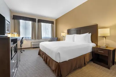 a hotel room with a large bed and a television at Best Western Plus Baker Street Inn in Nelson