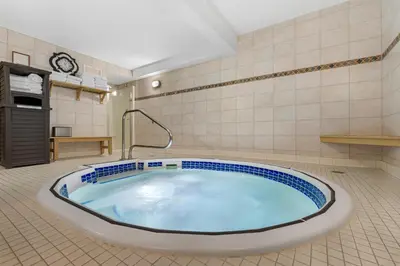 a large bath tub in a room with a tiled floor at Best Western Plus Baker Street Inn in Nelson