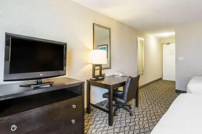 a hotel room with a desk with a television and a bed at Clarion Hotel & Conference Centre in Sherwood Park