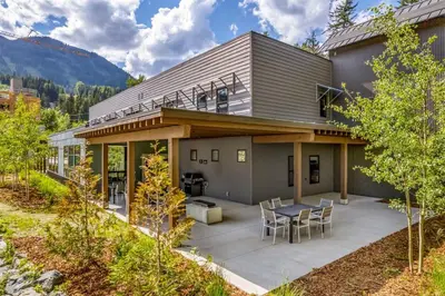 a house with a patio with a table and chairs at Nowhere Special Hostel in Rossland