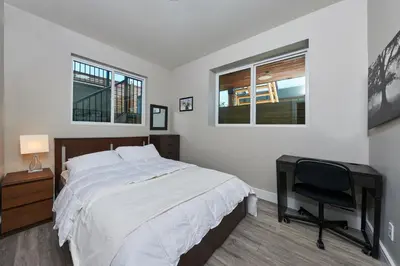 a bedroom with a bed and a desk and a chair at The Chateau in Burnaby
