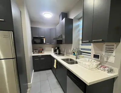a small kitchen with a sink and a refrigerator at The Chateau in Burnaby