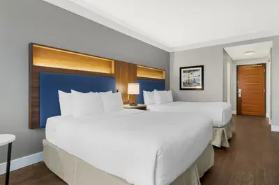 two beds in a hotel room with white sheets at Best Western Plus Revelstoke in Revelstoke