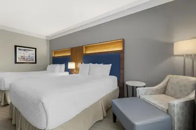 a hotel room with two beds and a chair at Best Western Plus Revelstoke in Revelstoke