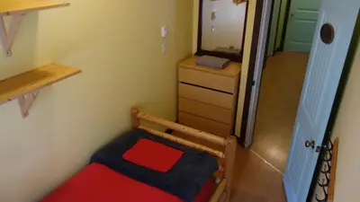 a small room with a chair and a mirror at Dreamcatcher Hostel in Golden