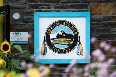 a sign on a brick wall with flowers at Dreamcatcher Hostel in Golden