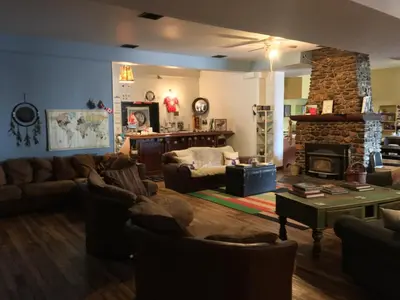 a living room with couches and a stone fireplace at Dreamcatcher Hostel in Golden