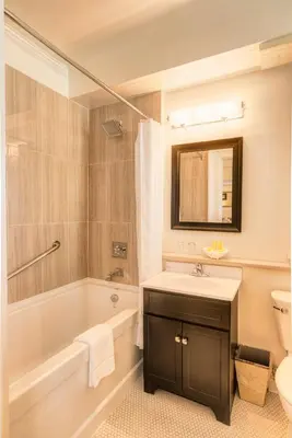 a bathroom with a sink and a tub and a toilet at The Inn at the Union Club of British Columbia in Victoria