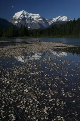a river with snow capped mountains in the background at Mount Robson Lodge in Mount Robson