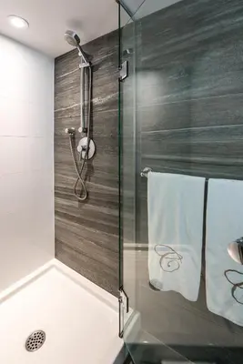 a bathroom with a shower with a glass door at Carmana Hotel & Suites in Vancouver