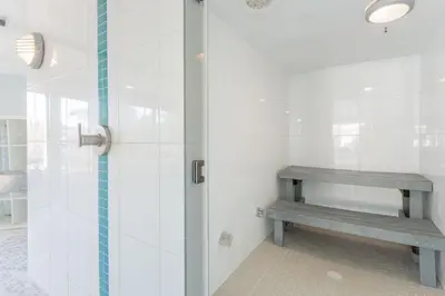 a shower stall with a bench in a bathroom at Mayne Island Resort in Mayne Island