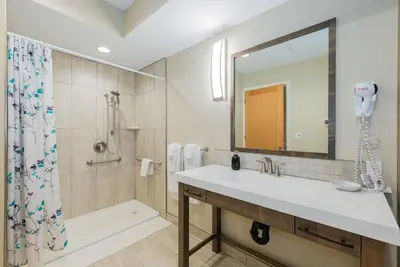 a bathroom with a sink and a shower and a mirror at Mayne Island Resort in Mayne Island