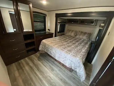 a bedroom with a large bed and a dresser at Noah's Ark Campground in Revelstoke